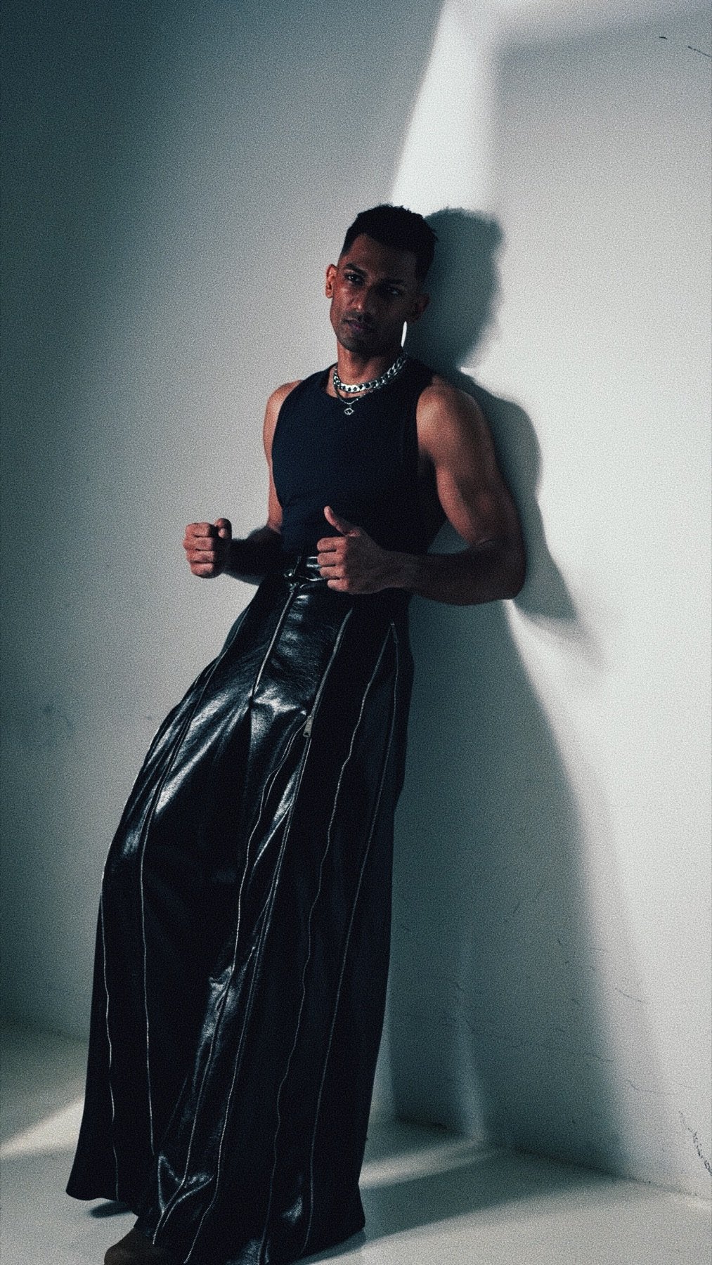 Studio portrait of Theebaan G against a lit wall