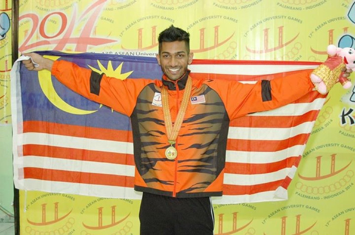 Theebaan G holding the Malaysian flag with a gold medal at the ASEAN University Games