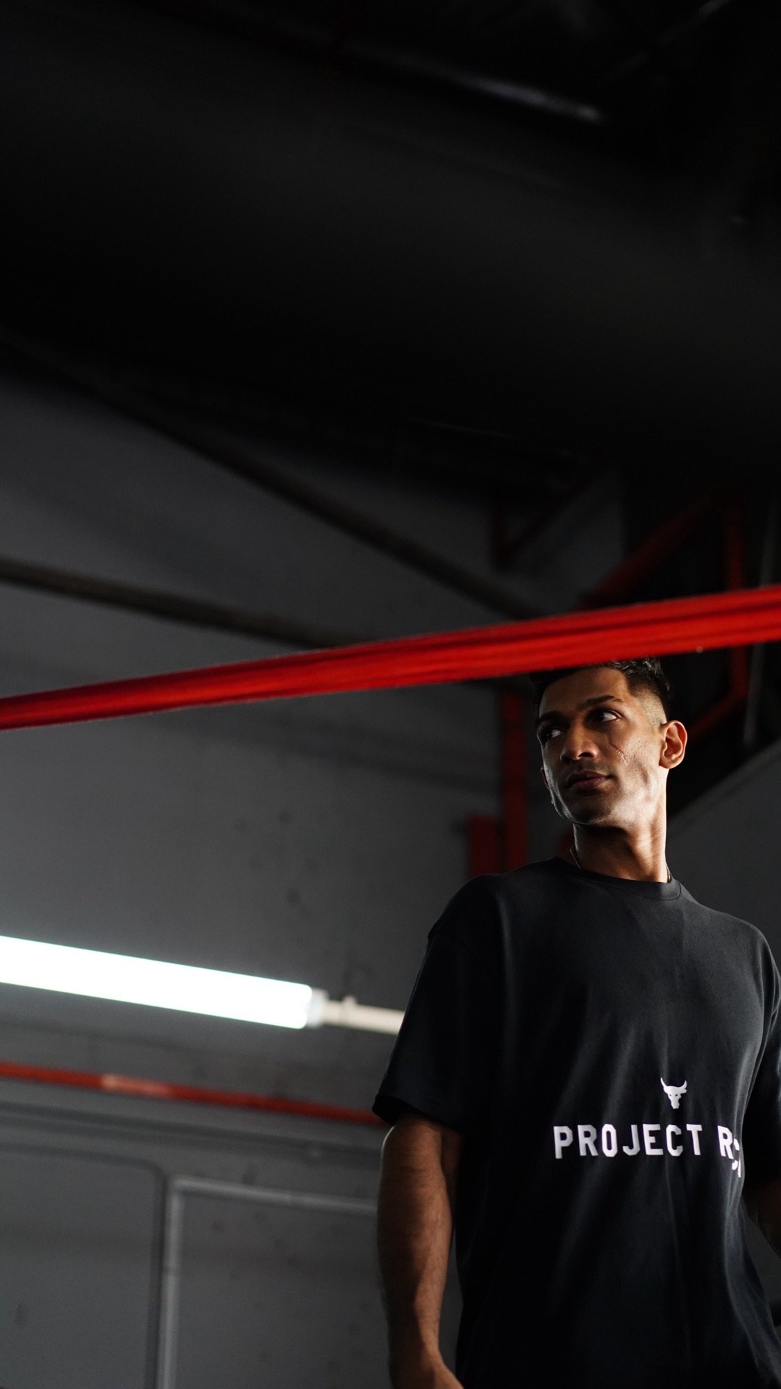Theebaan G standing beside a boxing ring